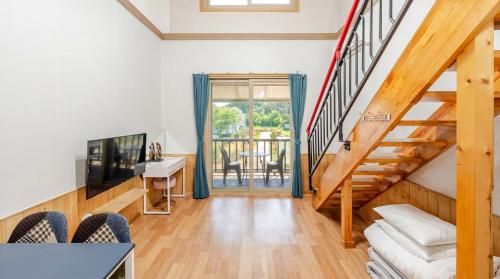 a living room with stairs leading to a balcony at suncheon romance pension in Suncheon