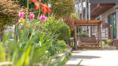 a bench and flowers in front of a building at suncheon romance pension in Suncheon