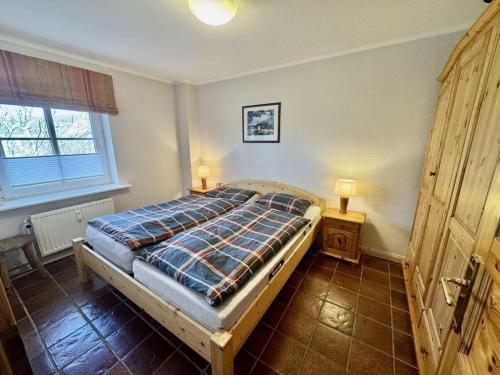 a bedroom with a bed and two lamps in it at Achtern-Diek-1 in Brösum