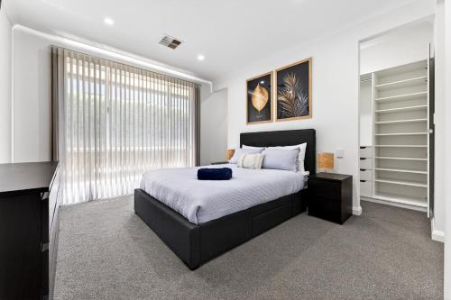 a bedroom with a bed and a large window at DEAR8 - Madeley Retreat in Perth