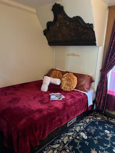 a bedroom with a red bed with two pillows at Aaron House of Niagara Falls in Niagara Falls