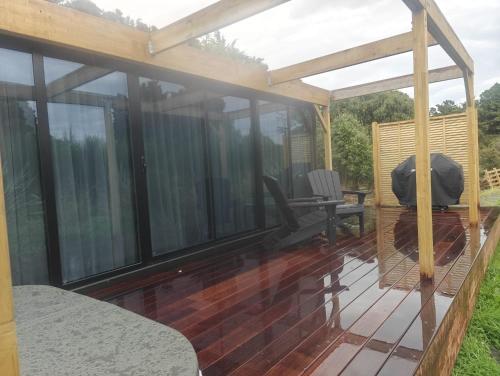 a screened in deck with a table and a chair at Huruhuru Hideaway! Private Cabin in Otatara