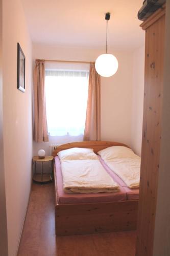 a bedroom with a bed in a room with a window at Deichblick 02 in Prerow