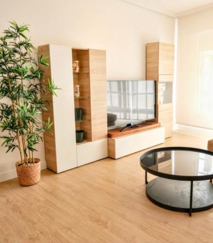 a living room with a glass table and a tv at Piano 8 Sanxenxo in Sanxenxo