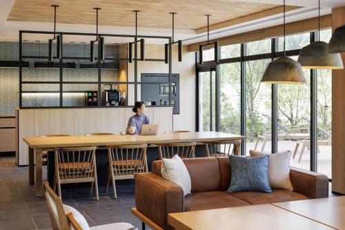 a person sitting at a kitchen table with a laptop at Fairfield by Marriott Okayama Hiruzen Highland in Maniwa