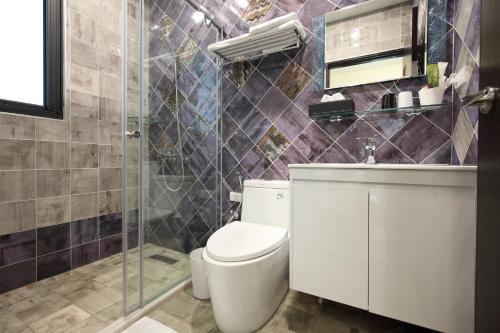 a bathroom with a toilet and a glass shower at Mr Lee Elevator B&B Hualien- Near Dongdamen Night Market in Ji'an