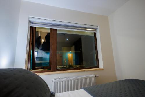 a window in a room with a bed and a chair at Hostal Royal Austral in Coihaique