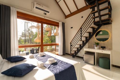 a bedroom with a large bed with blue pillows at I Ahangama - 100m to Kabalana Beach in Ahangama
