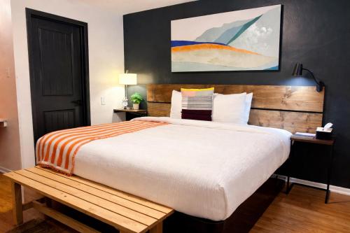 a bedroom with a large bed with a wooden headboard at The City Center Motel in Medford