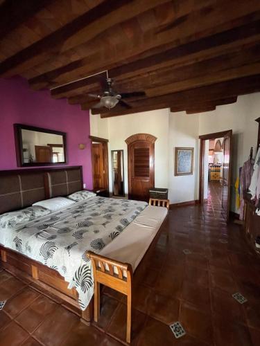 a large bedroom with a large bed with purple walls at Casa Bella in Puerto Escondido