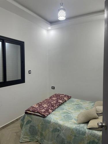 a bedroom with a bed with a pillow on it at Chez montasser in Al Maqārisah