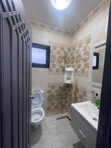 a bathroom with a toilet and a sink at Chez montasser in Al Maqārisah