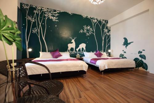 a bedroom with two beds and a green wall at Mr Lee Elevator B&B Hualien- Near Dongdamen Night Market in Ji'an