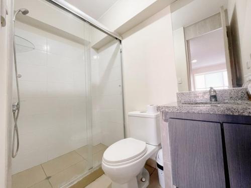 a bathroom with a toilet and a glass shower at Apacible y acogedora habitación con vista a Barranco in Lima