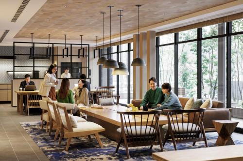 a group of people sitting at tables in a restaurant at Fairfield by Marriott Hiroshima Sera in Sera