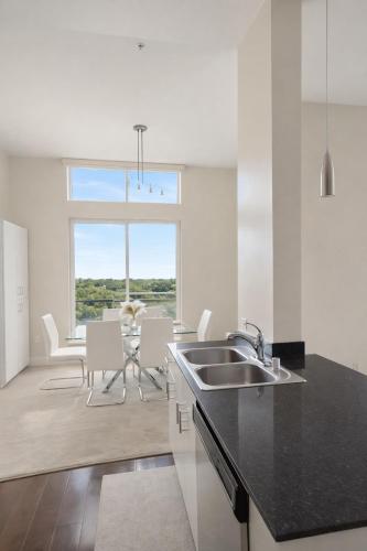 a kitchen with a sink and a table with chairs at Luxury 2 Bedroom 2 Bathroom With Fitness Center and Pool in Los Angeles