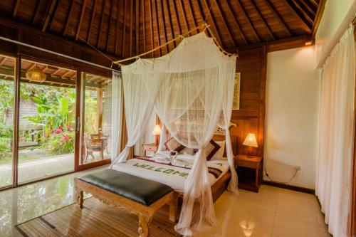 a bedroom with a bed with a mosquito net at Dukuh Sebatu Villa Ubud in Tampaksiring