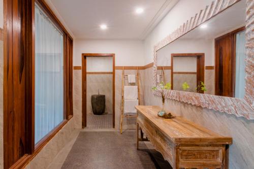 a room with a wooden bench and a mirror at Dukuh Sebatu Villa Ubud in Tampaksiring