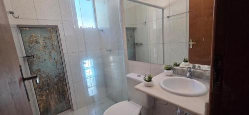 a bathroom with a toilet and a sink and a shower at Arandu chalés maresias in São Sebastião