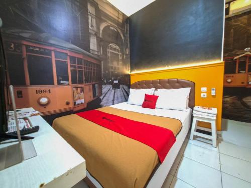 a bedroom with a bed with a red and yellow blanket at RedDoorz @ Jalan Tanjung Blitar in Blitar