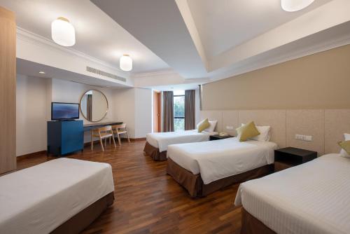 a hotel room with two beds and a mirror at YWCA Fort Canning in Singapore