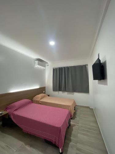 a room with two beds and a window at YOJU aparthotel in Colón