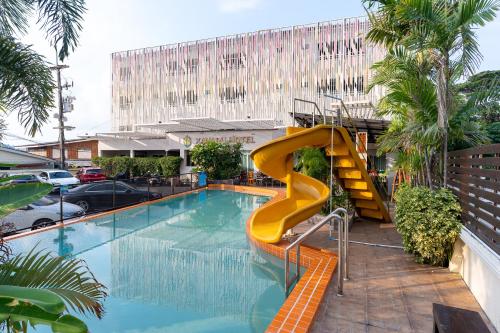 a swimming pool with a yellow slide in a building at Xanadu Hotel Utapao in Rayong