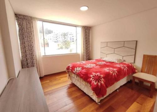 a bedroom with a red bed and a window at Salma in cuzco apart in Cusco