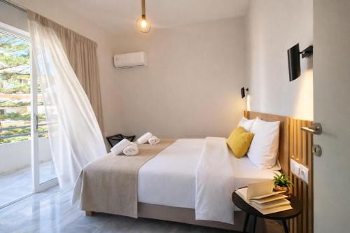 a hotel room with a bed and a window at Mardinik Hotel Apartments in Rethymno