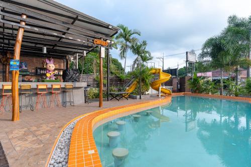 a swimming pool with a slide next to a resort at Xanadu Hotel Utapao in Rayong