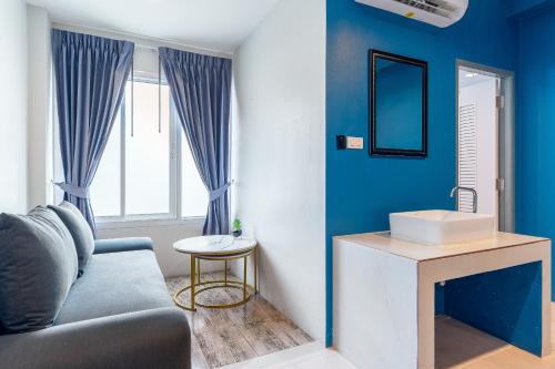 a blue living room with a couch and a sink at Xanadu Hotel Utapao in Rayong