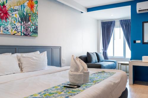 a hotel room with a bed and a chair at Xanadu Hotel Utapao in Rayong