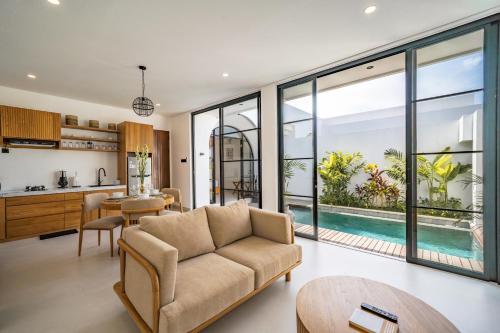 an open kitchen and living room with a couch and a table at Maui Bingin Villas in Uluwatu