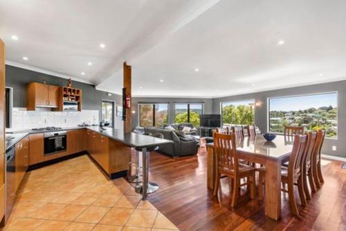 a large kitchen and living room with a table and chairs at Seasidestyle in Raglan