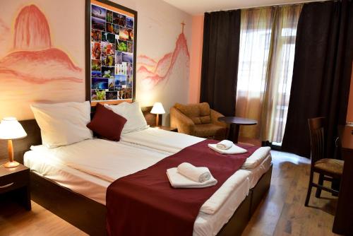 a hotel room with a bed with towels on it at Hotel Ida in Bansko