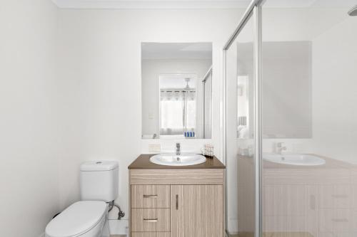 a bathroom with a toilet and a sink and a shower at Direct Collective - Breeze on Brightwater in Mooloolaba