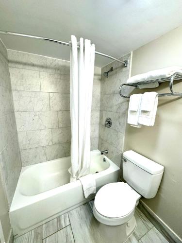 a bathroom with a toilet and a tub and a sink at Americas Best Value Inn Tulsa I-44 in Tulsa