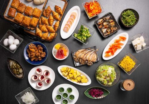 a table with plates of food and bowls of food at Shizutetsu Hotel Prezio Numazu in Numazu