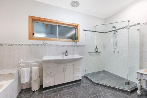 a bathroom with a shower and a sink and a tub at Morrissey Cottage in Warrnambool