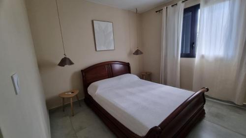 a small bedroom with a bed and a window at Villa Horizon Volcan in Saint-Philippe