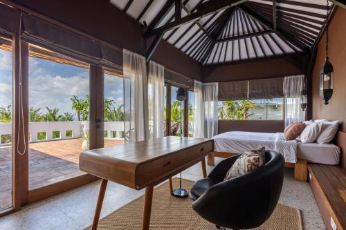 a bedroom with a bed and a table and a chair at Nami House Balian in Balian