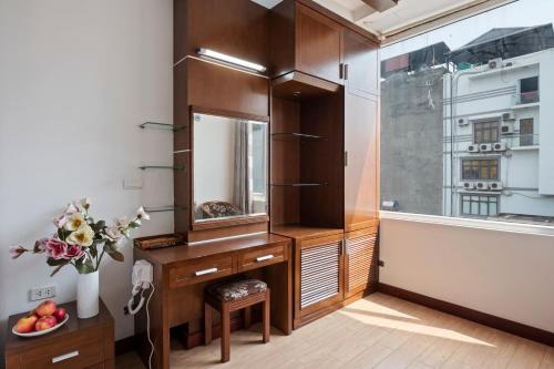 a bathroom with a vanity with a mirror and a window at Eco Nest Signature Hotel in Hanoi