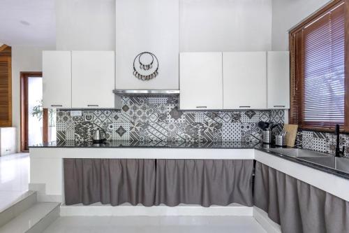 a kitchen with white cabinets and a sink at Nami House Balian in Balian