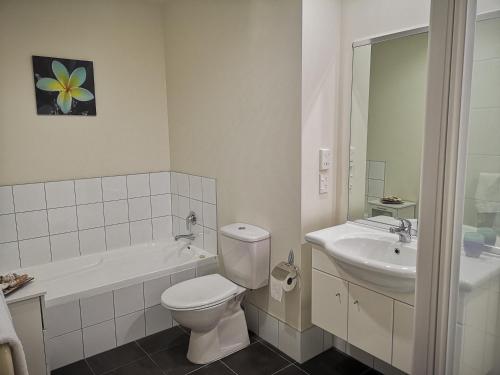 a white bathroom with a toilet and a sink at Tutukaka Marina Views in Tutukaka