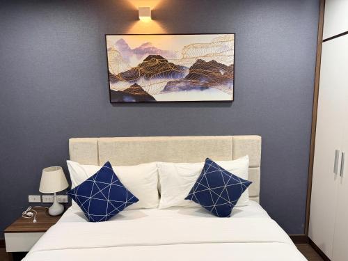 a bedroom with a bed with blue and white pillows at Ha Long 2BR Apartment - Spacious & Modern - Near Center in Ha Long