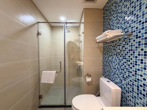a bathroom with a toilet and a glass shower at Ha Long 2BR Apartment - Spacious & Modern - Near Center in Ha Long