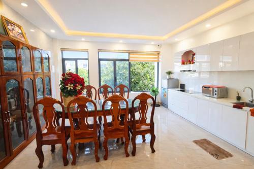a kitchen with a dining room table and chairs at Sunhouse Villa Huế in Hue