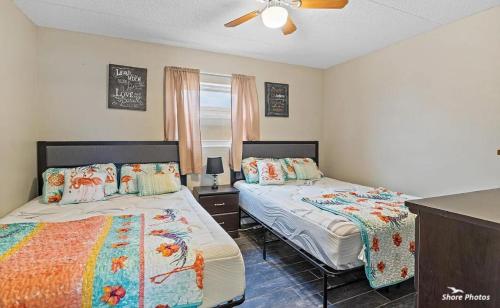 a bedroom with two beds and a ceiling fan at 1 Bedroom Beach Condo with a Pool & Balcony in Wildwood Crest