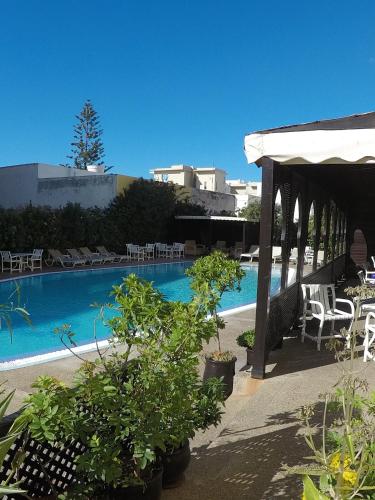 a swimming pool with chairs and a pavilion at Riad Zahra in Essaouira