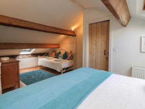 a bedroom with a bed and a couch in a room at Canalside Cottage in Kildwick